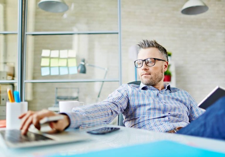photo of a man wearing glasses working on a laptop