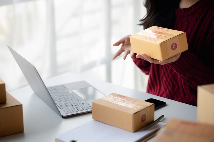 photo of a woman with packages and a laptop